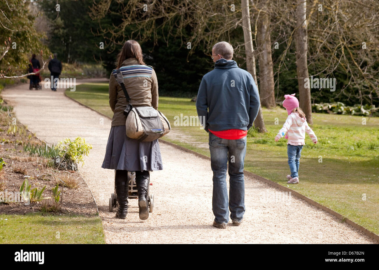 Una familia a caminar en el parque, la madre, el padre y el hijo visto desde la parte trasera, REINO UNIDO Foto de stock