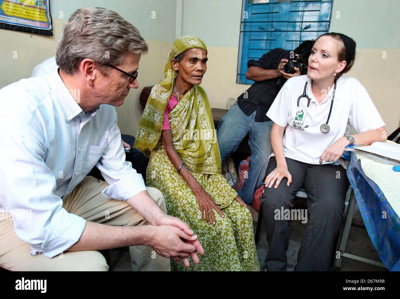 Bundesaußenminister Guido Westerwelle (FDP) und die Ärztin Louise Kühne sitzen mit einer unterernährten Patientin am Samstag (23.06.2012) en einer Arztpraxis der Hilfsorganization "Ärzte für die 3. Welt' im von Korail tugurios en Dhaka (Bangladesch). Hier die deutsche Ärzte versorgen ehrenamtlich Bedürftigen. Foto: Jan Woitas dpa +++(c) dpa - Bildfunk+++ Foto de stock