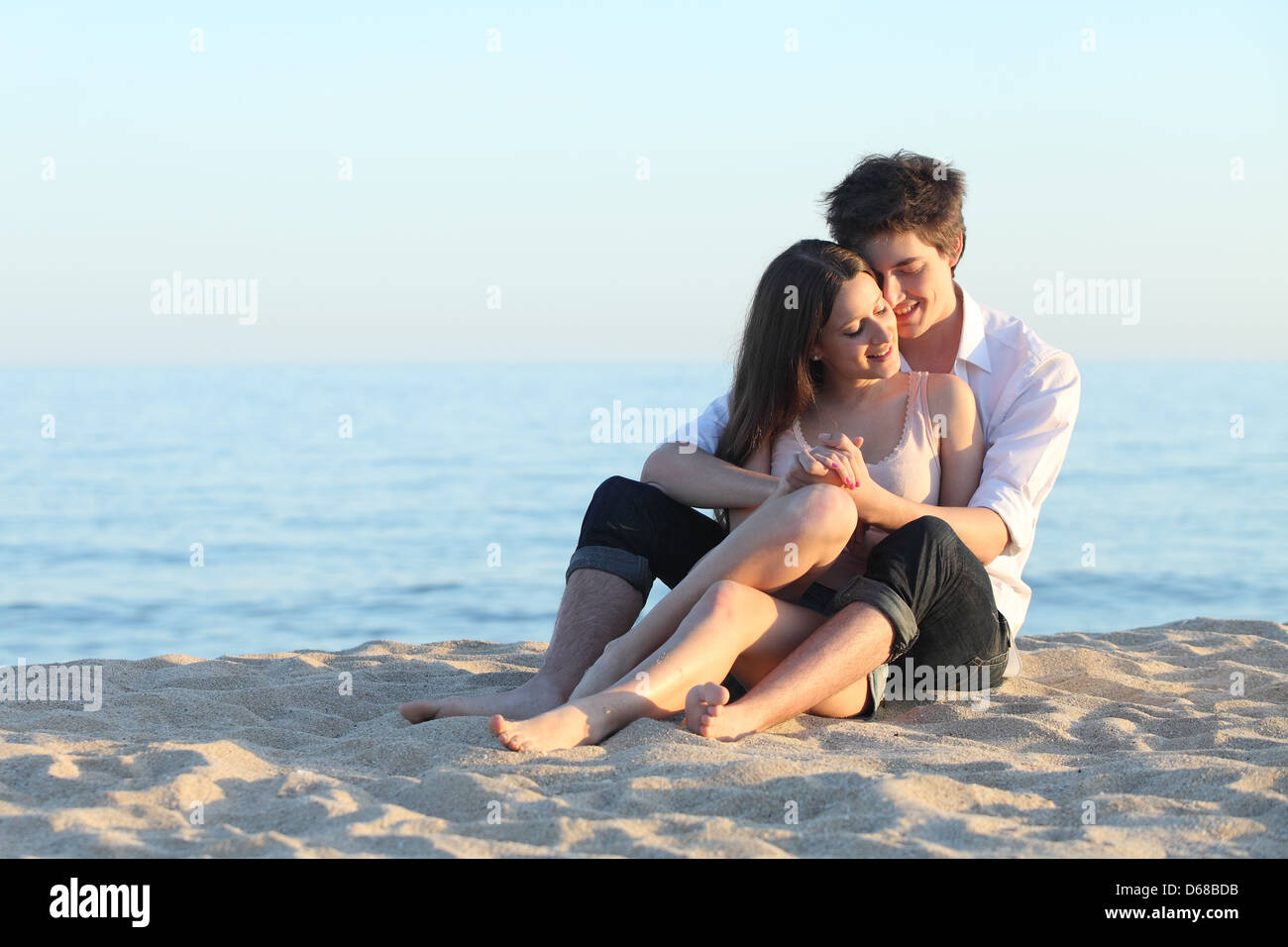 Pareja abrazada sentado en la arena de la playa, con el mar de fondo Fotografía de stock - Alamy Pareja abrazada sentado en la arena de la playa, con el mar de fondo Fotografía de stock - Alamy