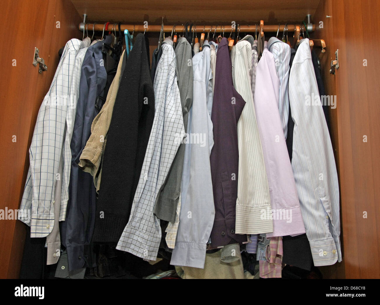 Dentro de un armario con muchos elegantes camisas para hombres Foto de stock