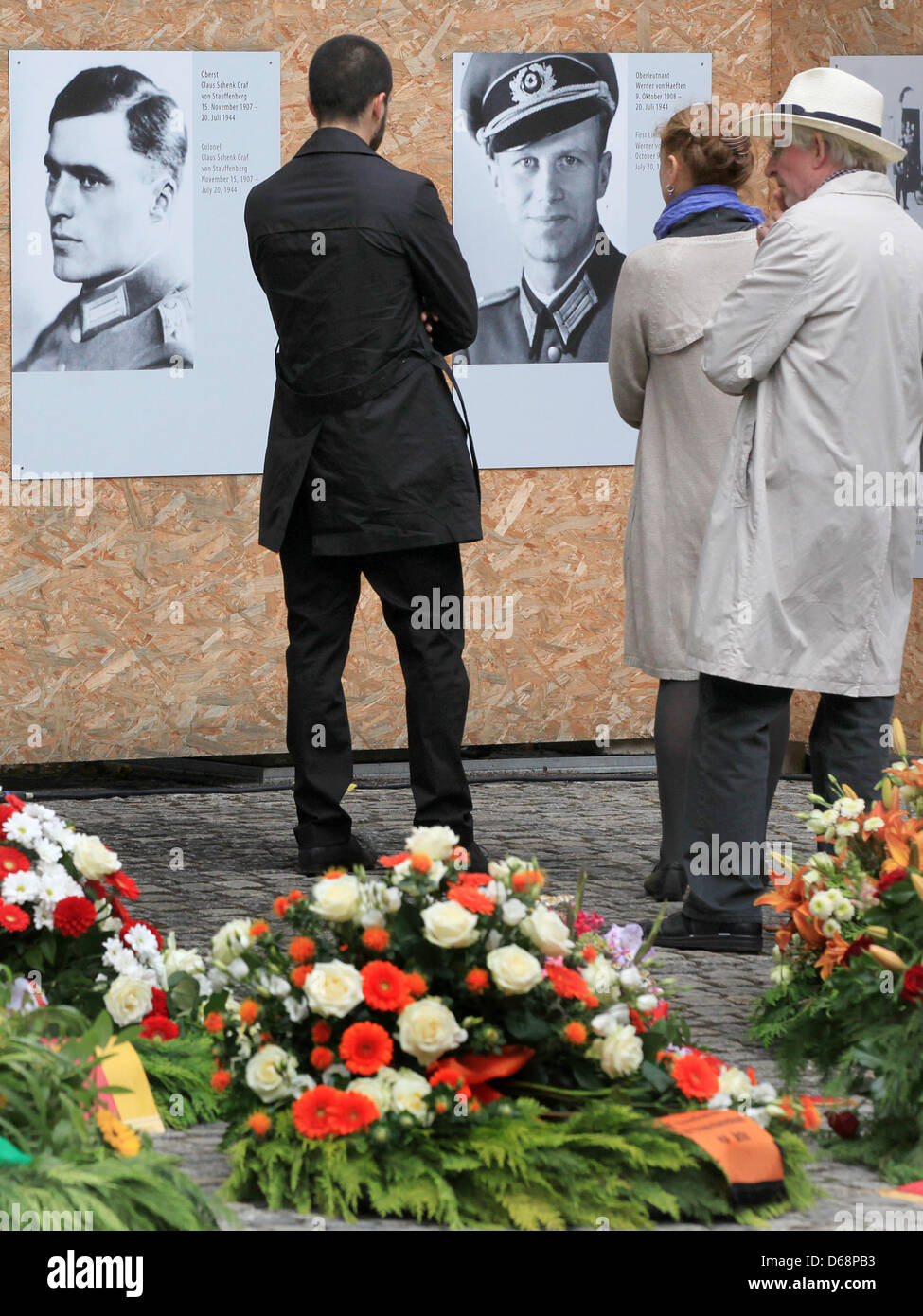 Los invitados mirar los retratos de los combatientes de la resistencia Claus Schenk Graf von Stauffenberg (L) y Oberleutnant Werner von Haeften durante un acto conmemorativo para conmemorar el 68º aniversario del intento de asesinato de 1944, Adolf Hitler, en el Bendlerblock de Berlín, Alemania, el 20 de julio de 2012. El Bendlerblock sirvió como sede de la Wehrmacht oficiales que llevaron a cabo la Foto de stock
