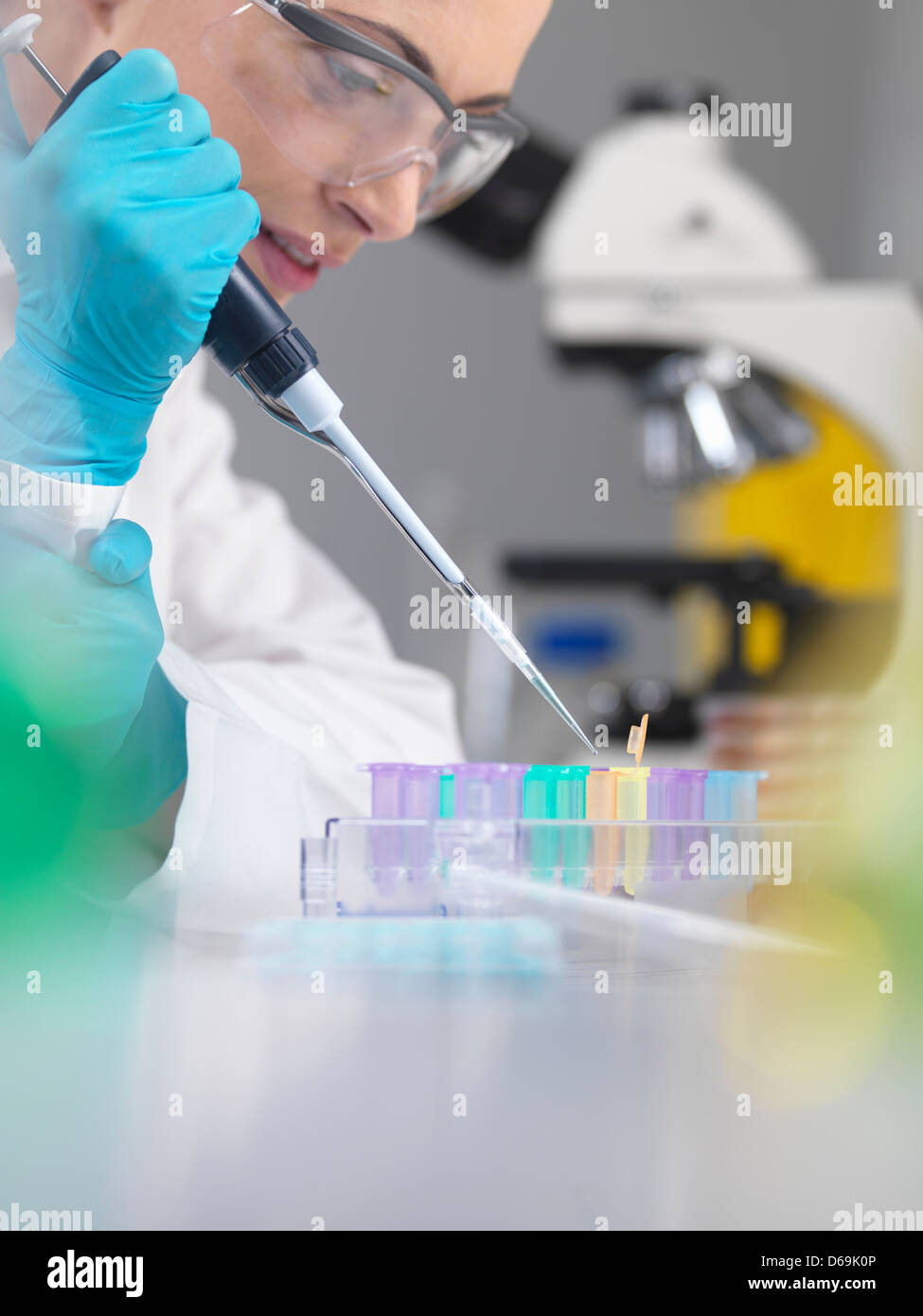 Scientist en tubos de muestras de ADN de pipeteado Foto de stock