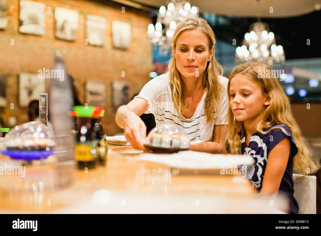 Madre e hija comiendo en el restaurante Foto de stock