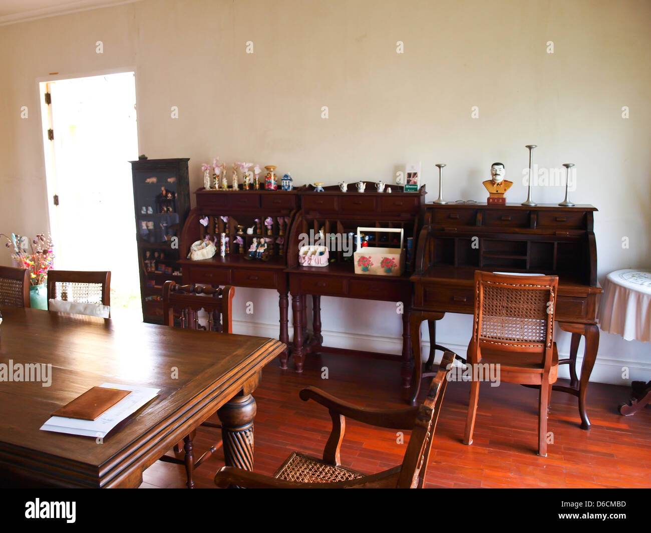Comedor interior con muebles marrones clásicos y luz natural. Foto de stock