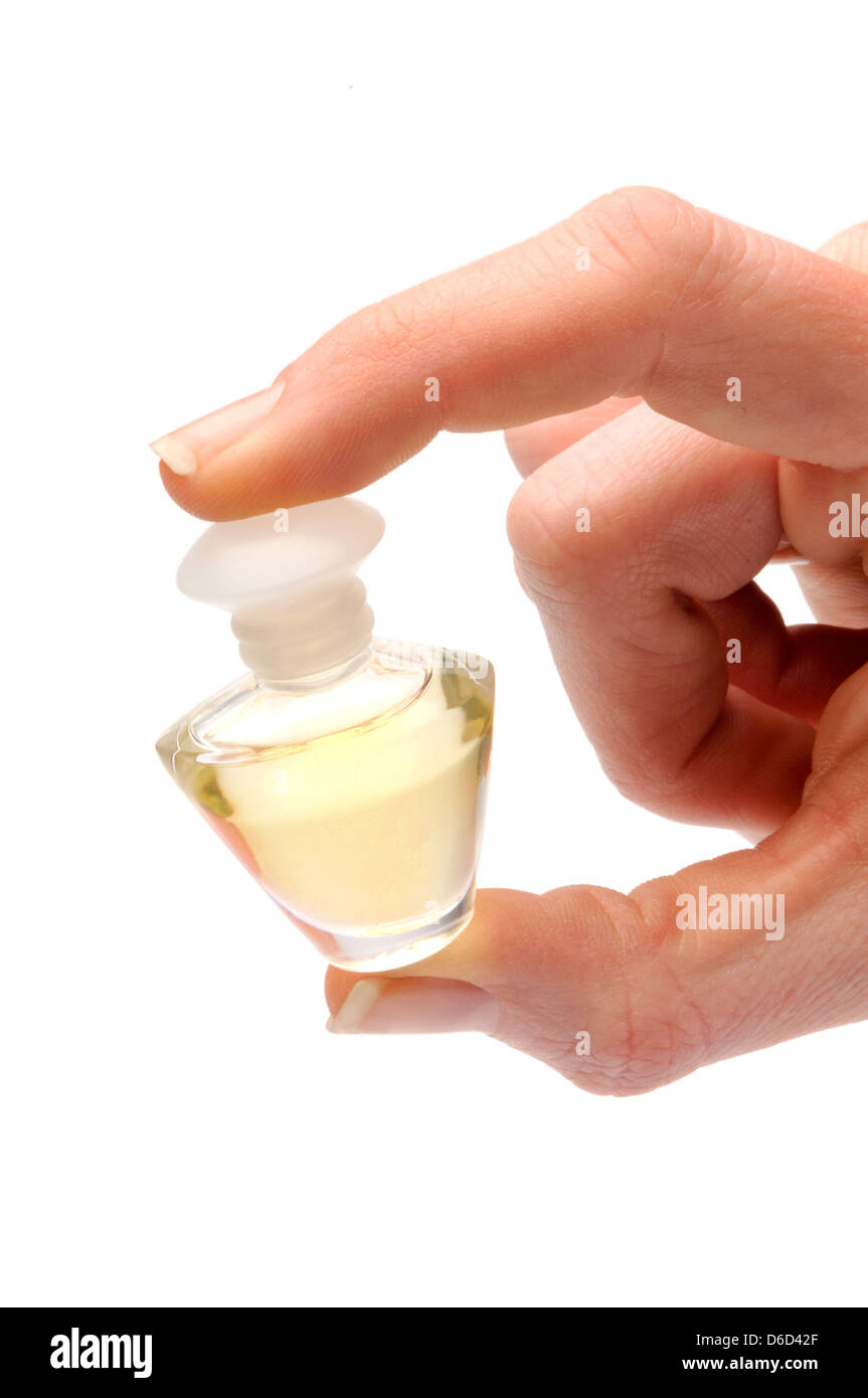 Mano sosteniendo pequeños frascos de perfume Foto de stock