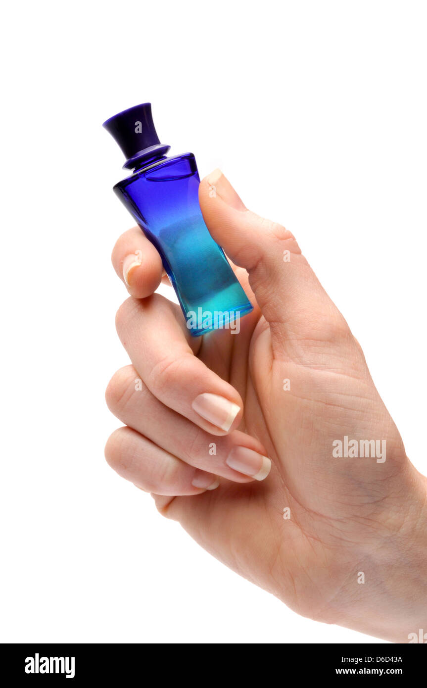 Mano sosteniendo pequeños frascos de perfume Foto de stock