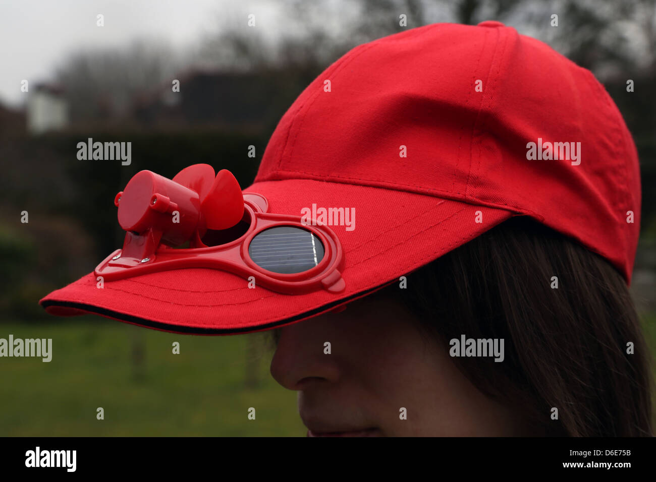 Mujer vestidos de rojo gorra con ventilador Solar Foto de stock