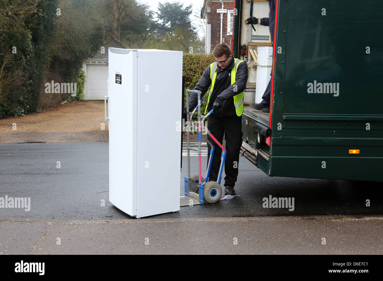 John Lewis entregando un congelador hombre usando un saco Barrow para mover pesados congelador Inglaterra Foto de stock