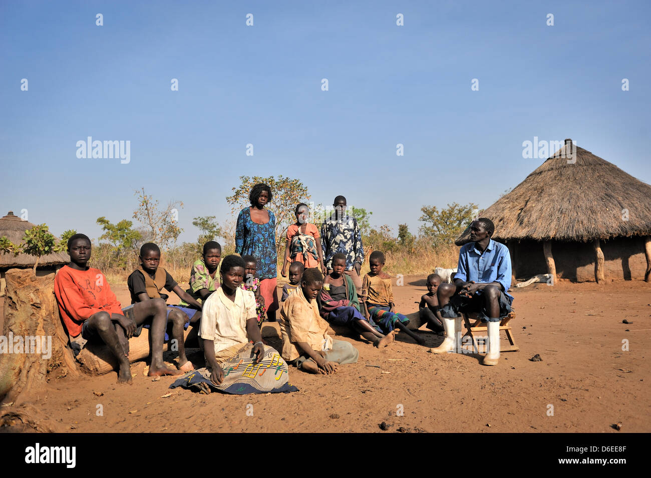 Agricultor Ociti Languna Augustino (R) se encuentra con su familia en frente de una cabaña en el distrito de Kitgum, Uganda del Norte, 17 de enero de 2012. 15 de sus 24 hijos padecen enfermedades asintiendo con la cabeza, que es una enfermedad nueva y desconocida, que apareció por primera vez en Sudán en 1980. Los enfermos, los niños entre 5 y 15 años de edad, son personas con discapacidad física y mental. La mayoría de los casos son por el momento Foto de stock