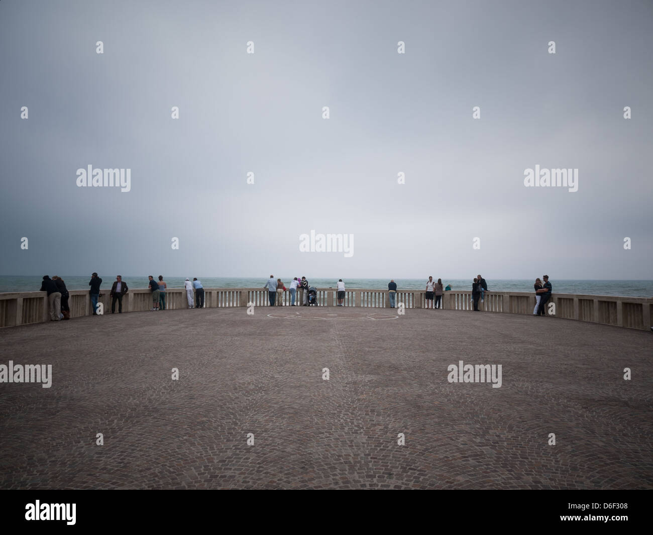 La gente mira al mar sobre el pontón de ciudad costera, Ostia, Roma Foto de stock