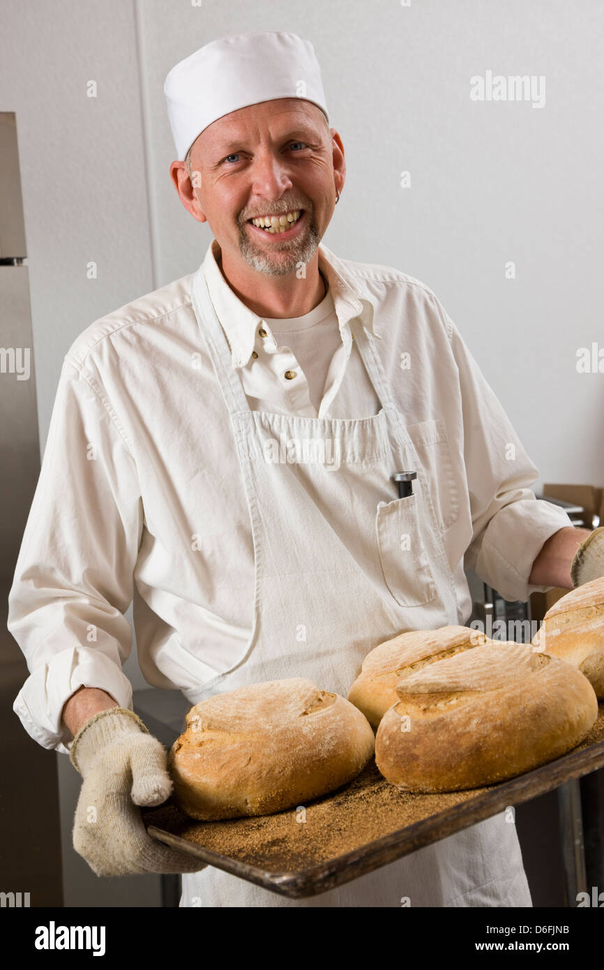 Cocinero profesional Preparando pan fresco en una panadería comercial Foto de stock