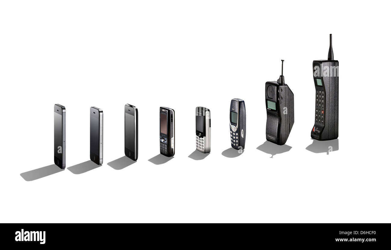 Una gama de teléfonos móviles que muestra su evolución con sombras. Foto de stock