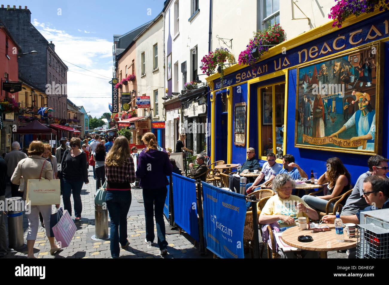 Los turistas de comer en la calle alta de la ciudad de Galway Irlanda Foto de stock