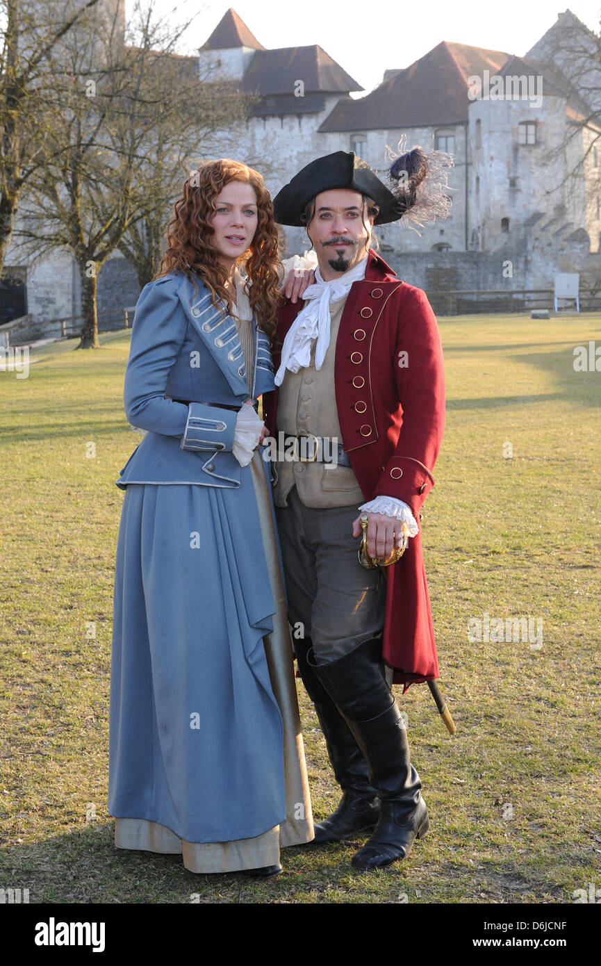 Los actores Jan Josef Liefers como Baron von Muenchhausen y Jessica Schwarz como Constanze von Hellberg sonrisa en el castillo de Burghausen en Altoetting, Alemania, el 14 de marzo de 2012. La película de tres partes sobre el Barón será mostrado durante la Navidad de 2012, en alemán ARD de broadcast. Foto: Ursula Dueren Foto de stock