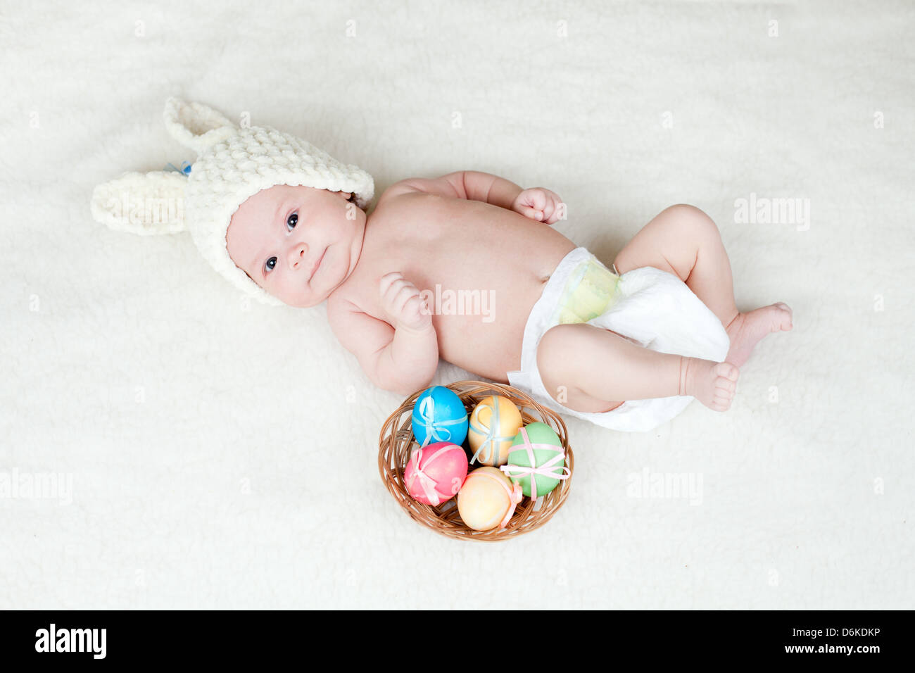 Adorable bebe vestidos en tapa de conejito de Pascua con huevos en la cesta  Fotografía de stock - Alamy