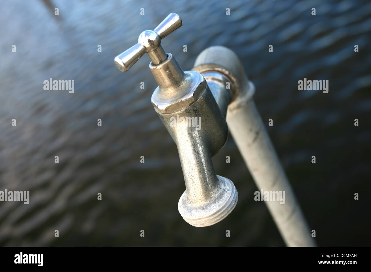 Grifo de agua cerrado con fondo de agua Fotografía de stock - Alamy