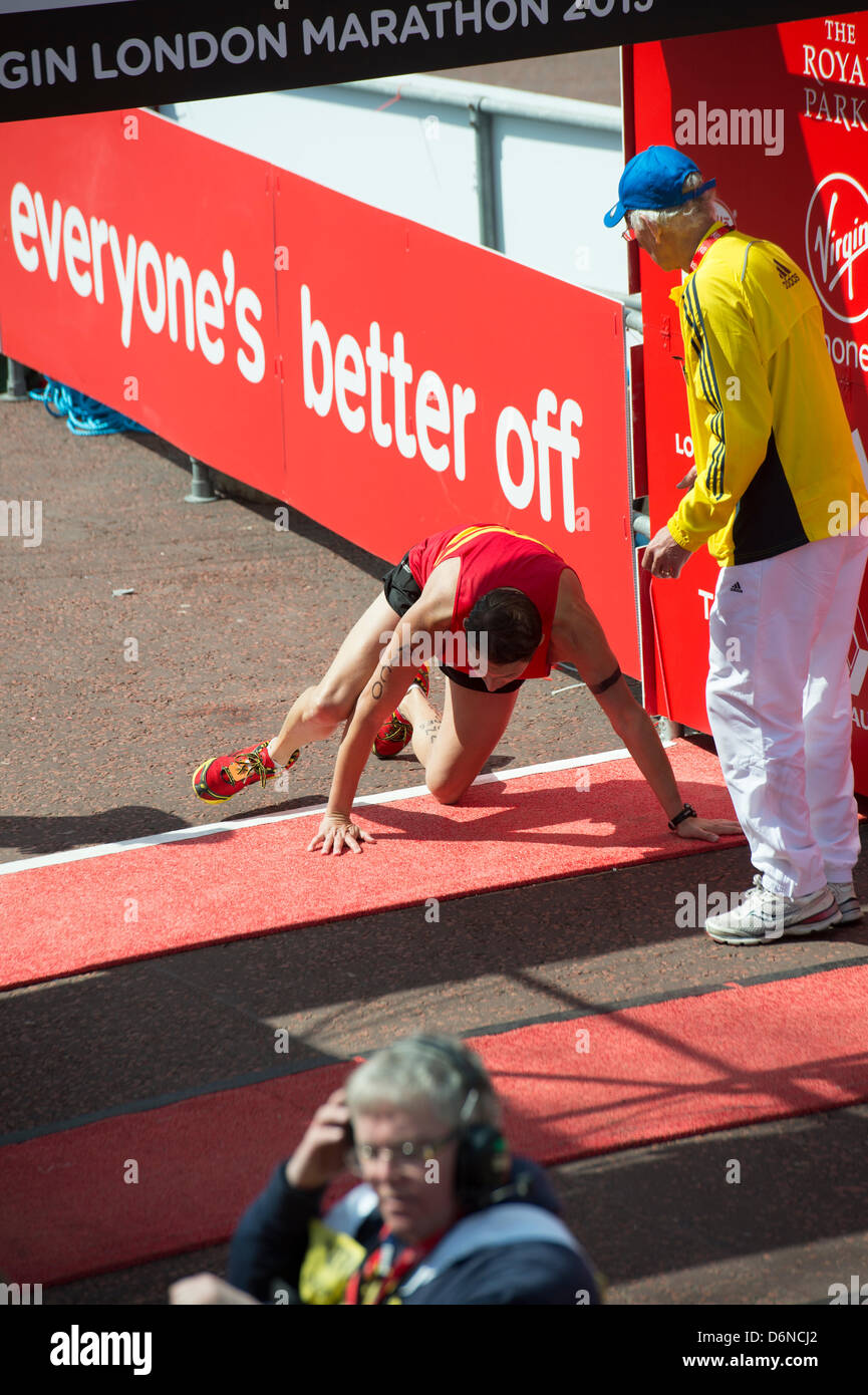 Un corredor se derrumba y arrastra sobre la línea de meta de la Maratón de Londres de 2013 Virgin en el Mall. Foto de stock