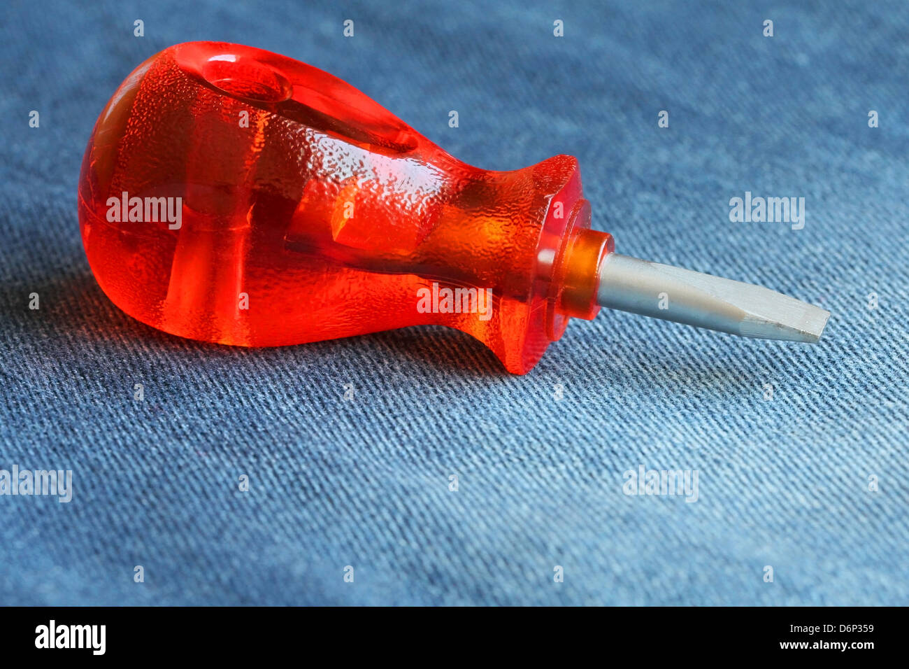 Cerca de un pequeño destornillador con mango de plástico rojo sobre azul  denim Fotografía de stock - Alamy