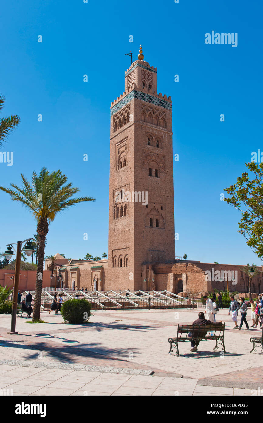 El hombre marroquí sentado en un banco en frente de la Mezquita de Koutoubia, Marrakech, Marruecos, África del Norte, África Foto de stock