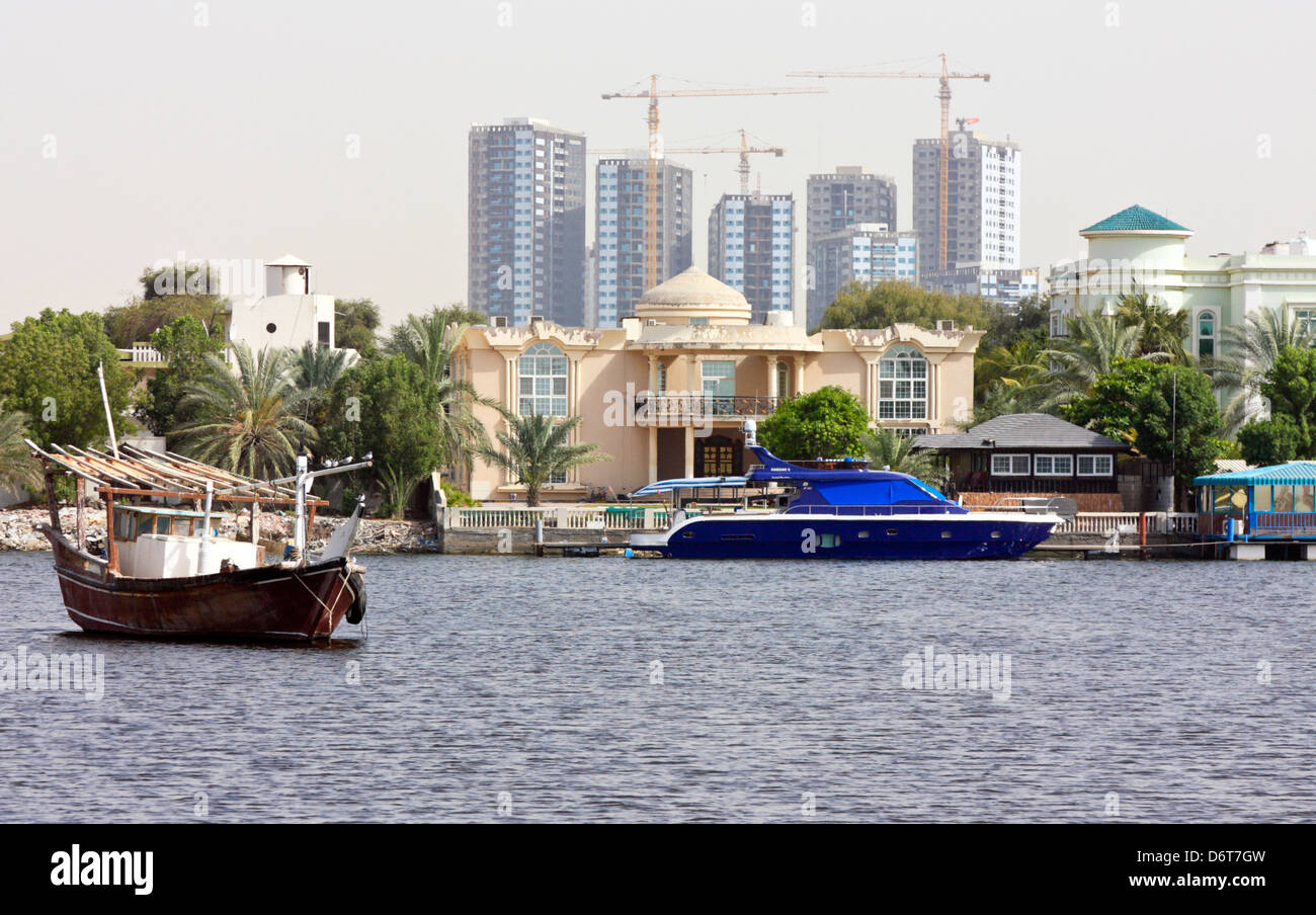 Zona residencial con embarcadero y yate a motor, Ajman, Emiratos Arabes Unidos Foto de stock