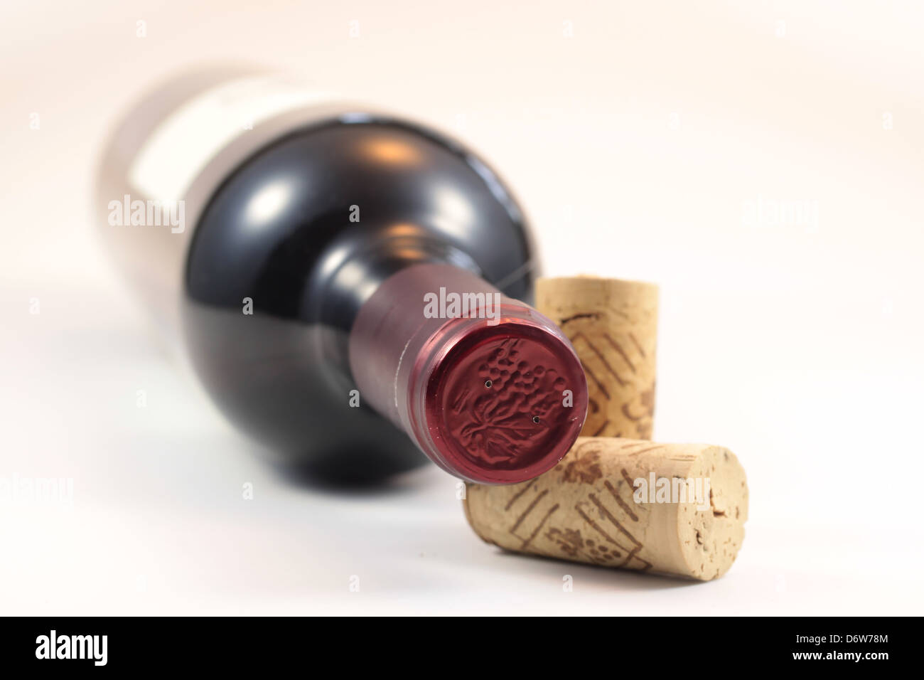 Corchos aislados y botella de vino rojo con fondo blanco. Foto de stock