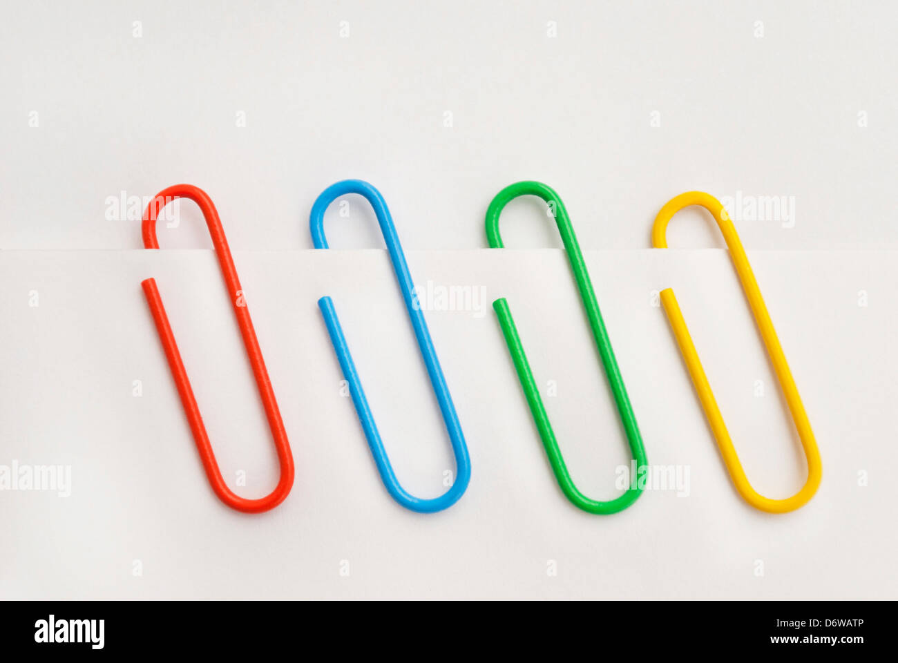 Cuatro clips de diferentes colores sobre el papel Fotografía de stock