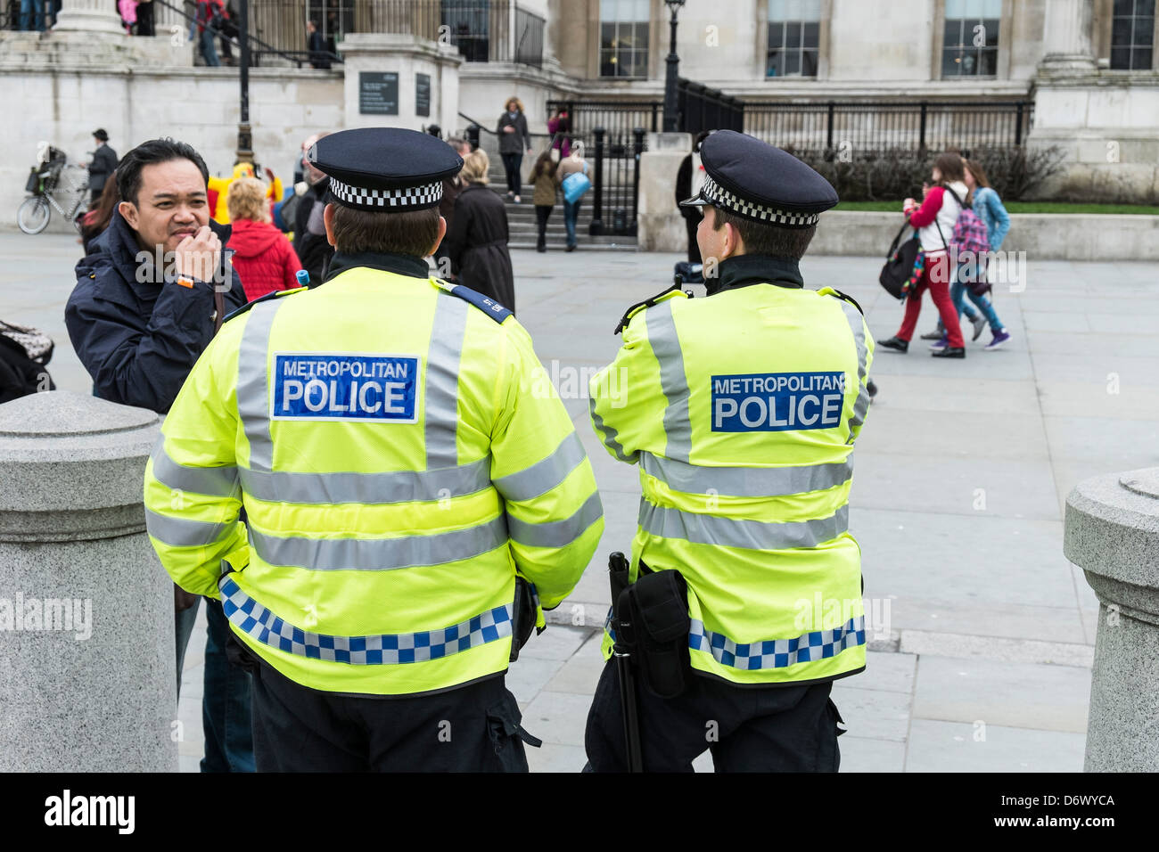 Dos funcionarios de la Policía Metropolitana para hablar a un turista en Londres. Foto de stock