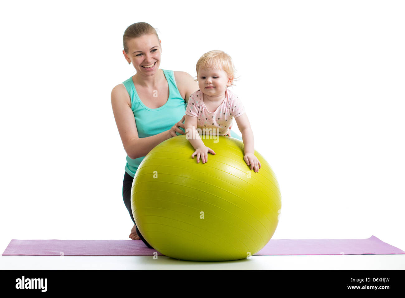 Madre haciendo gimnasia con el bebé sobre la bola de fitness Foto de stock