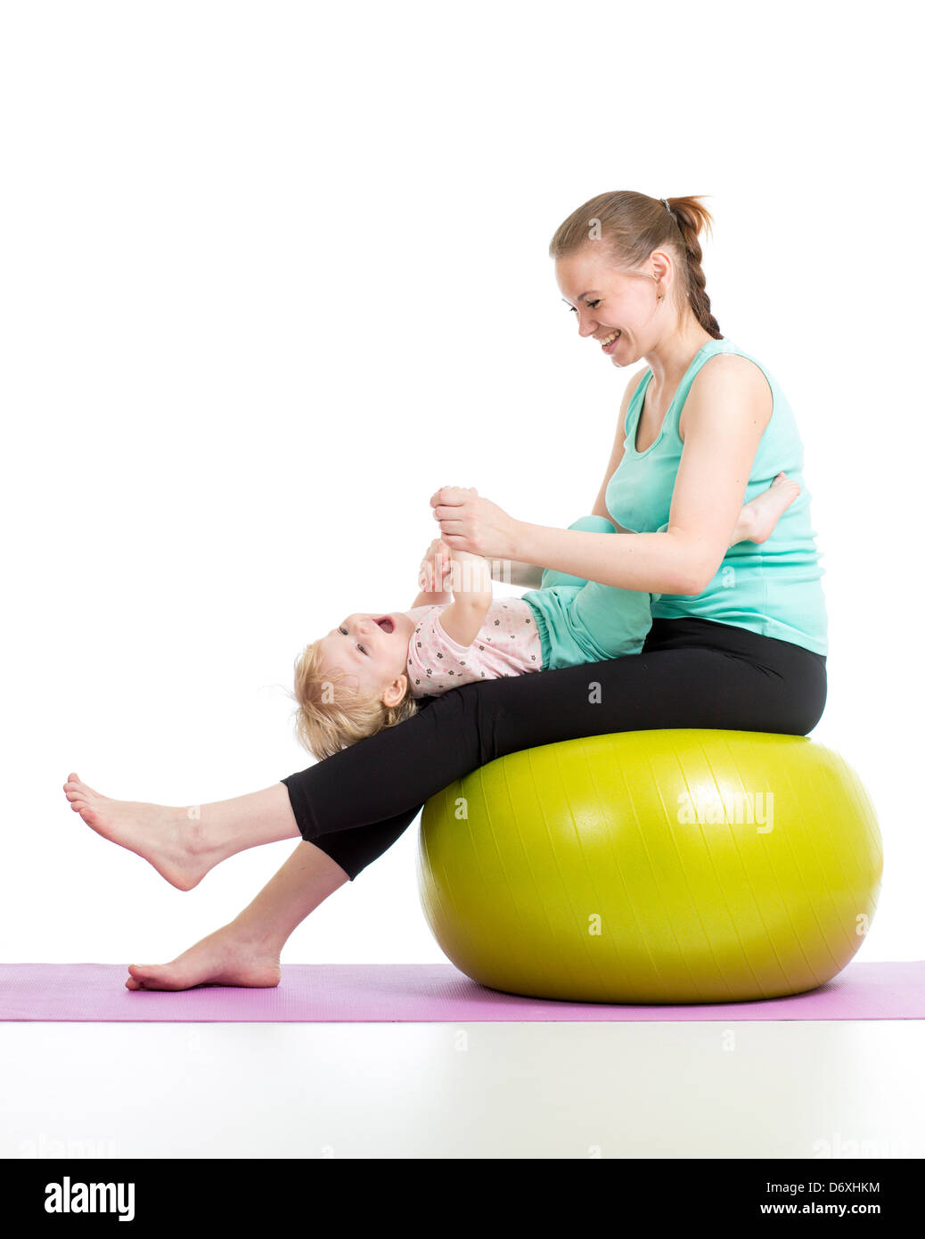 Madre haciendo gimnasia con el bebé sobre la bola de fitness Foto de stock