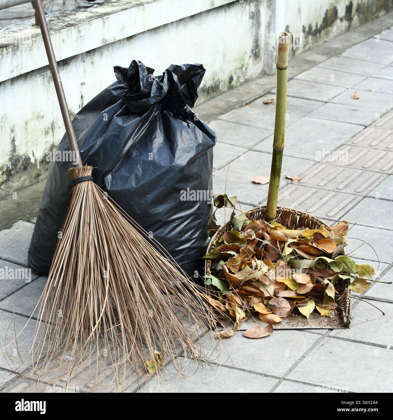 Hojas Secas, escoba, boca de desechos y bolsas de basura en la acera  Fotografía de stock - Alamy