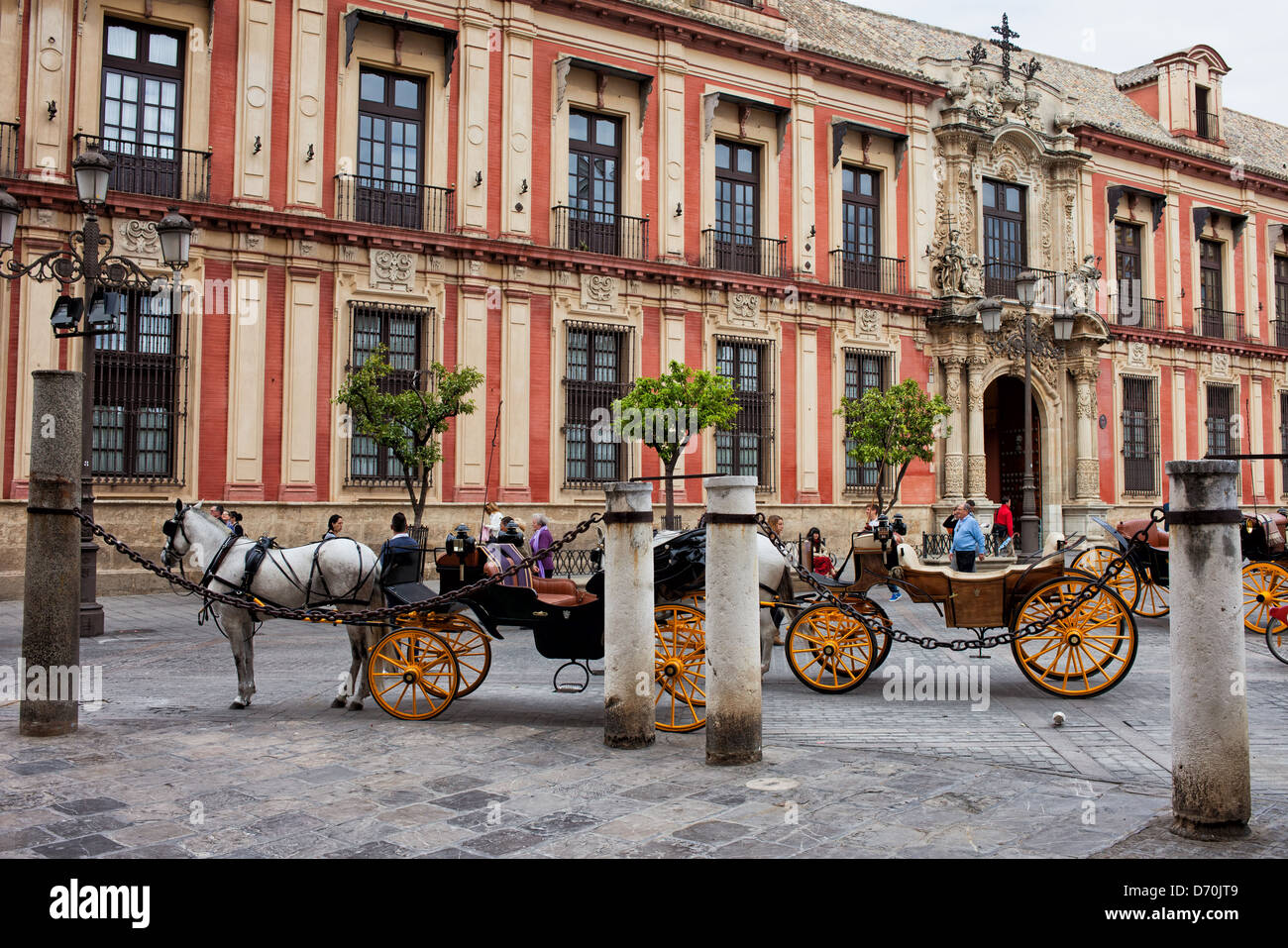 Ciudad Vieja de Sevilla pintoresca arquitectura histórica (zona próxima a la Catedral) y carruajes de caballos, Andalucía, España. Foto de stock
