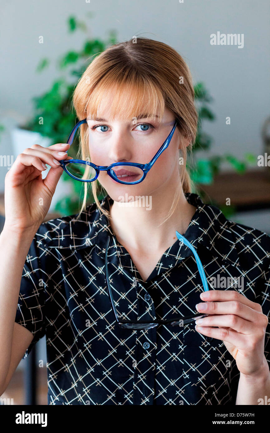 Mujer probando diferentes marcos para lentes recetados en el óptico