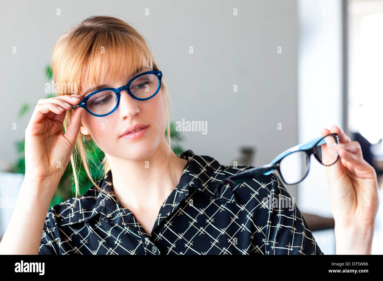 Mujer probando diferentes marcos para lentes recetados en el óptico  Fotografía de stock - Alamy