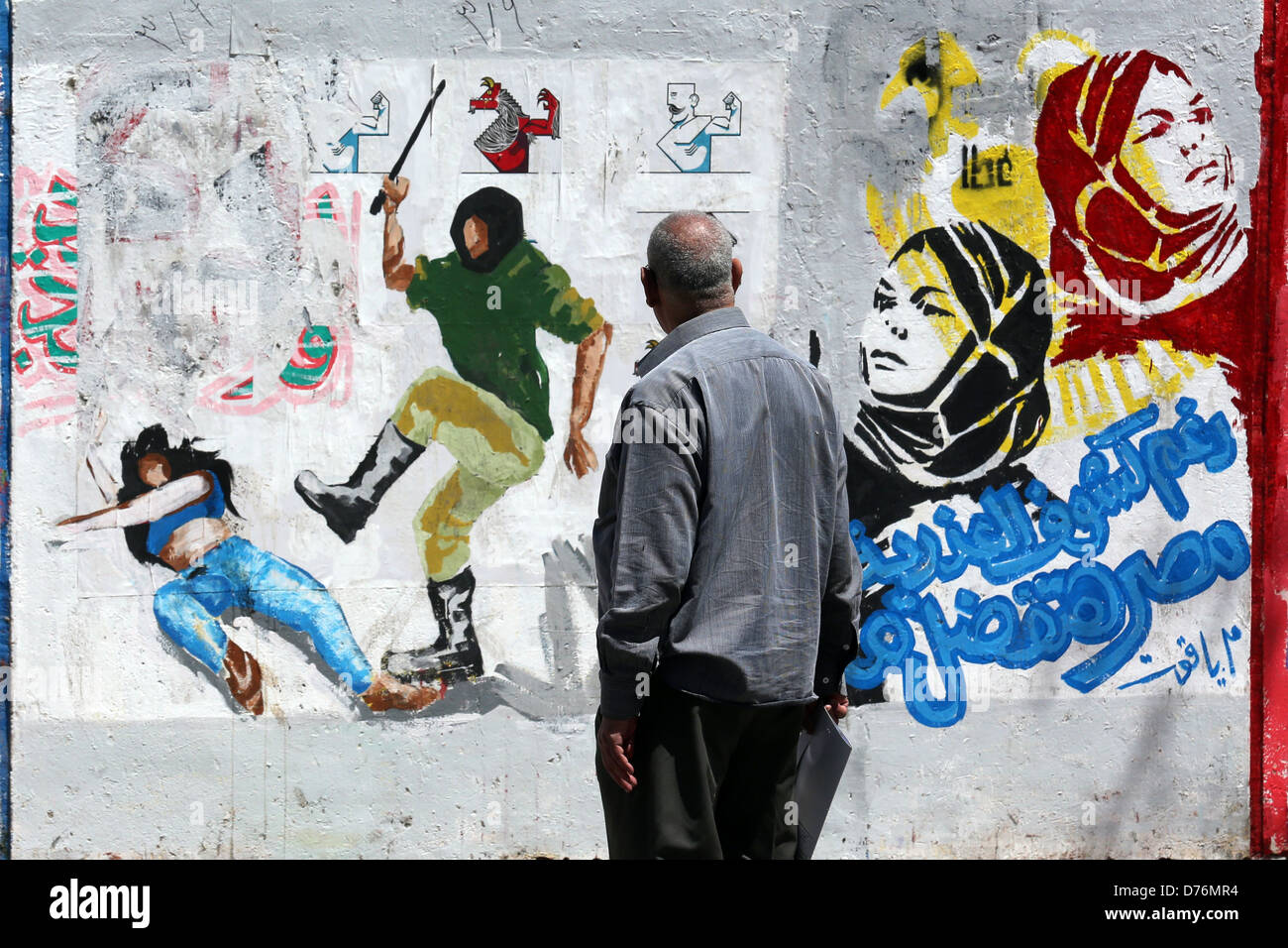 El hombre mira un revolucionario mural sobre una pared de los mártires, cerca de la plaza Tahrir en El Cairo. Foto de stock