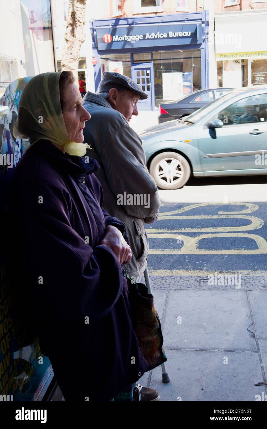 Una pareja de ancianos esperando en una parada de autobús. Foto de stock