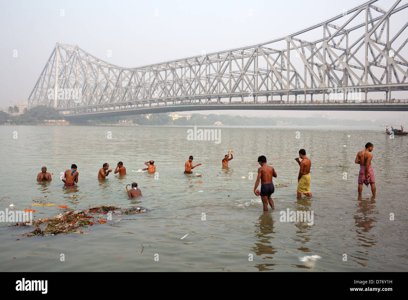 Las personas tomar baño matinal en el río Hooghly cerca de Howrah Bridge (Rabindra Setu) en Calcuta, India. Foto de stock