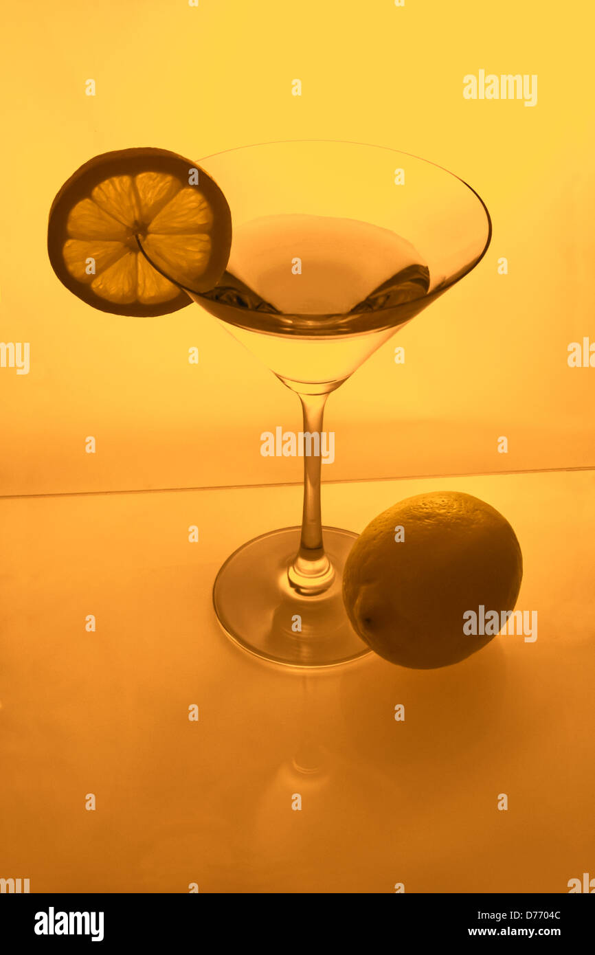 Copa de Martini con rodaja de limón y limón desde arriba en luz ámbar Foto de stock