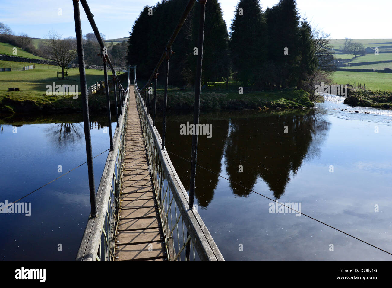 Reflexiones desde el puente colgante sobre el río Wharfe cerca de Hebden en Dales forma Sendero de Larga Distancia Yorkshire Foto de stock