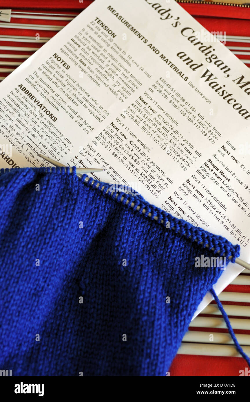 Blue STOCKING STITCH con el patrón y las agujas de tejer. Foto de stock