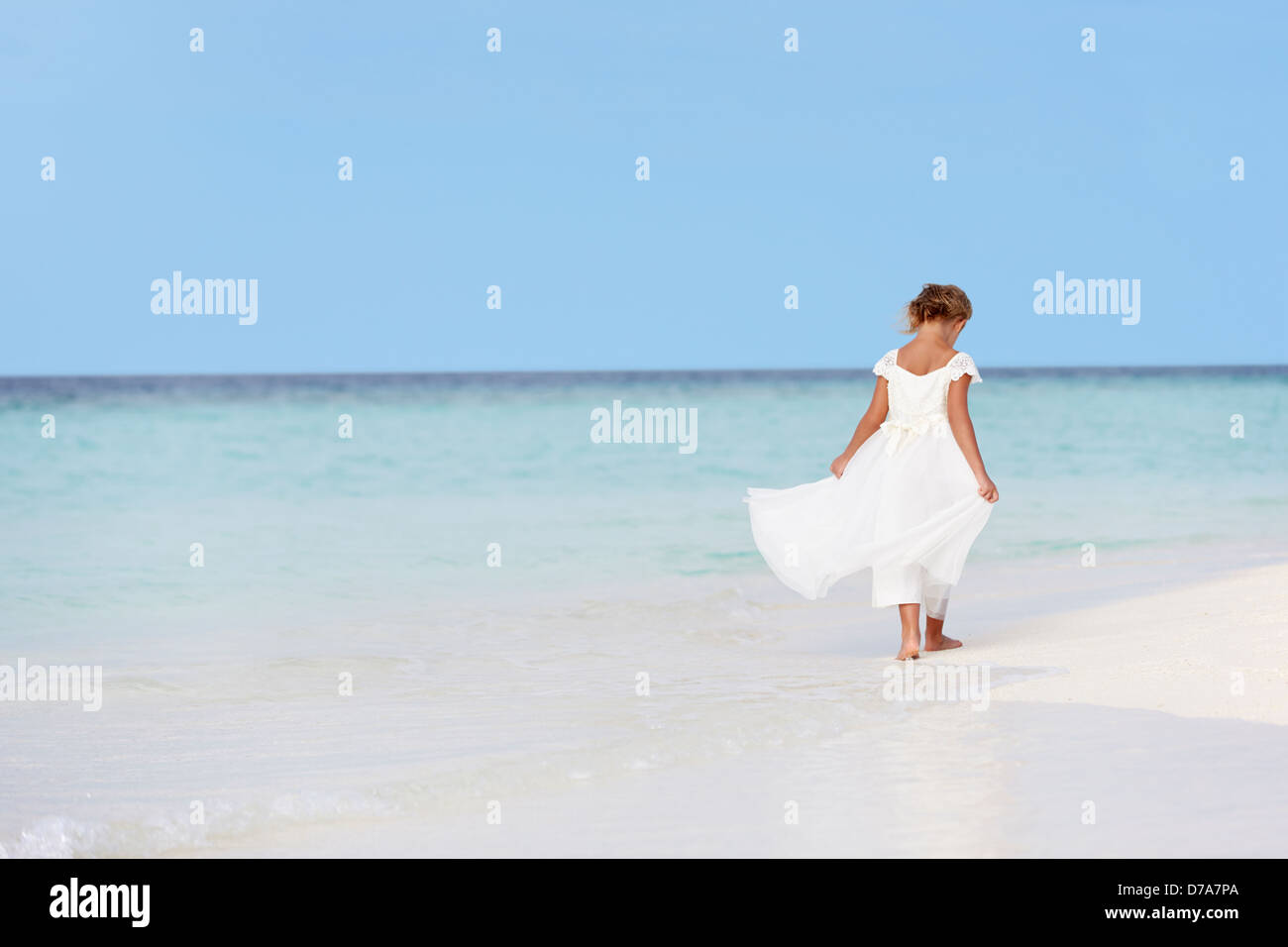 Chica Bridesmaid Dress caminar sobre la hermosa playa Foto de stock
