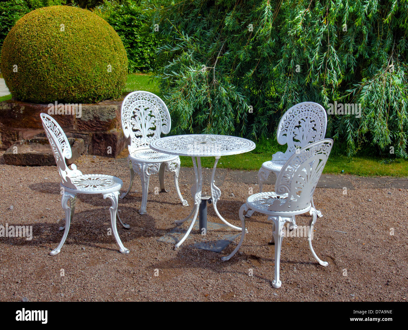 515-Juego de jardín formado por: mesa redonda y 4 butacas en hierro forjado  y pintado en blanco. Tapa de mesa en piedra con decoración de mármol de  colore