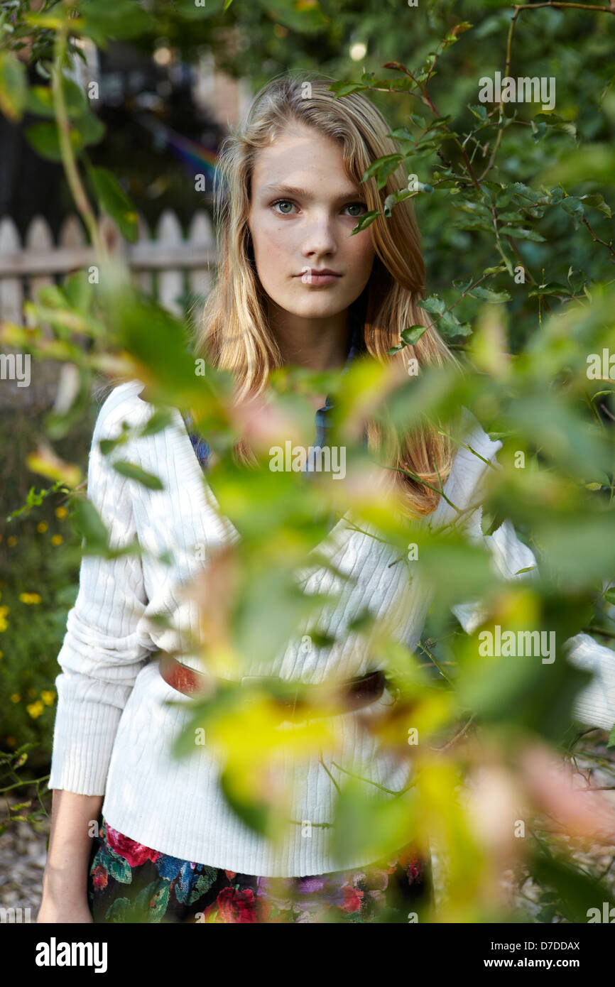 Hermosa teen detrás de árbol en el jardín Foto de stock