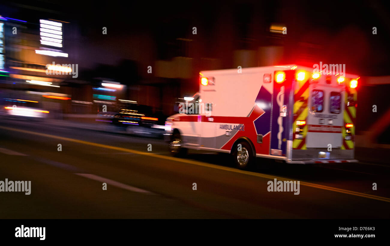 Una ambulancia la aceleración mediante el tráfico por la noche. Foto de stock