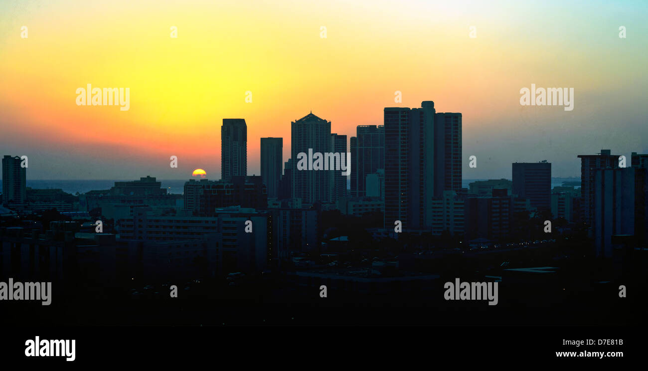 Último rayo de sol se esconde detrás de un horizonte de la ciudad Foto de stock