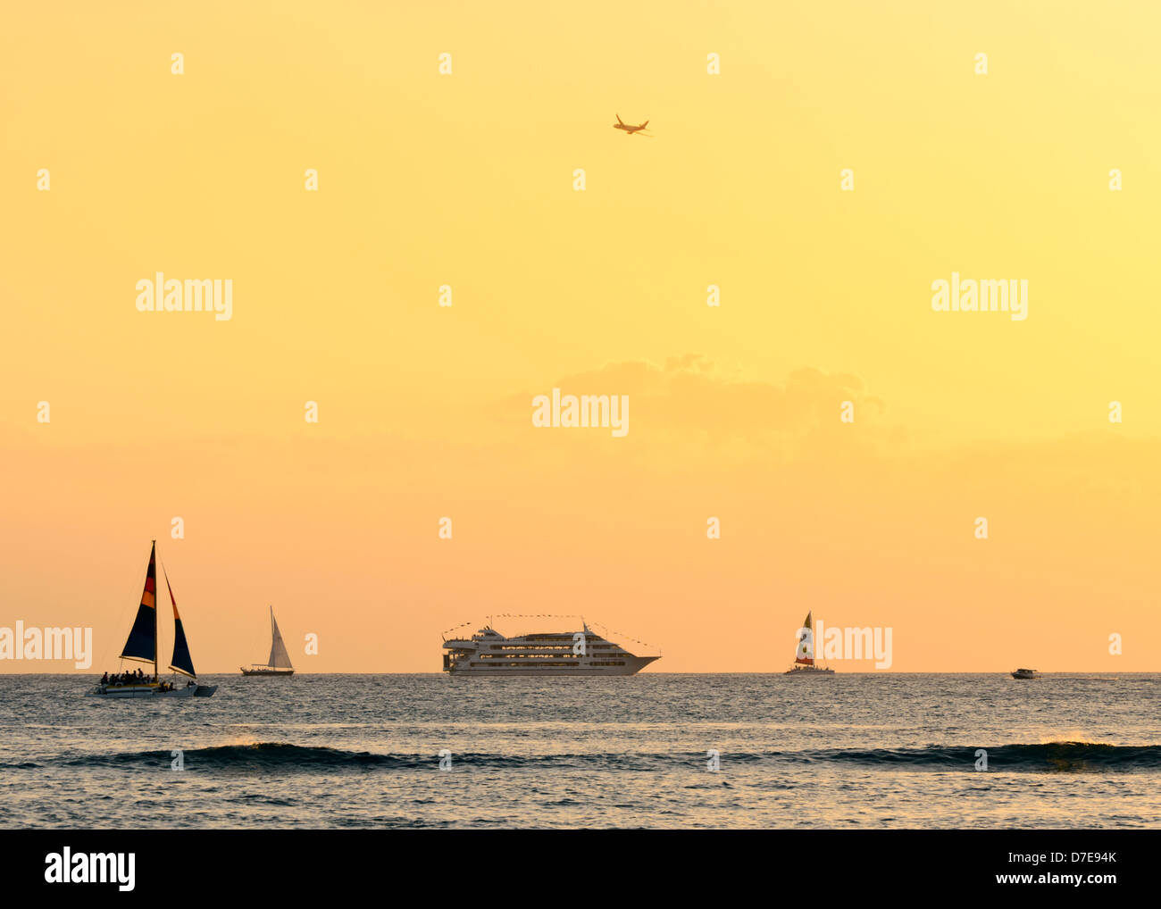 Varios barcos al mar fuera de Waikiki Beach para ver la hermosa puesta de sol hawaiana. Foto de stock