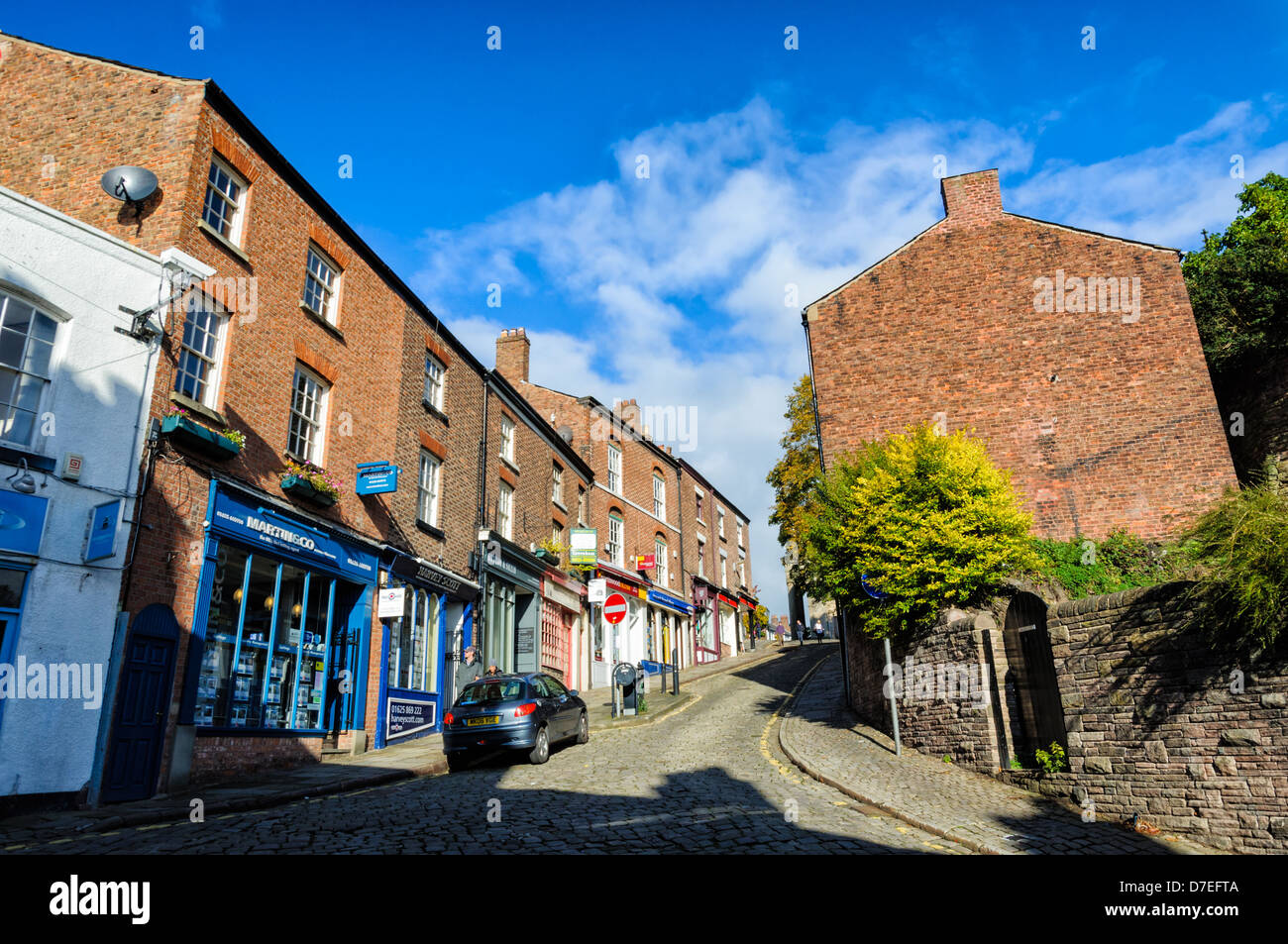 Empinada calle adoquinada en un típico pueblo del molino inglés del norte Foto de stock