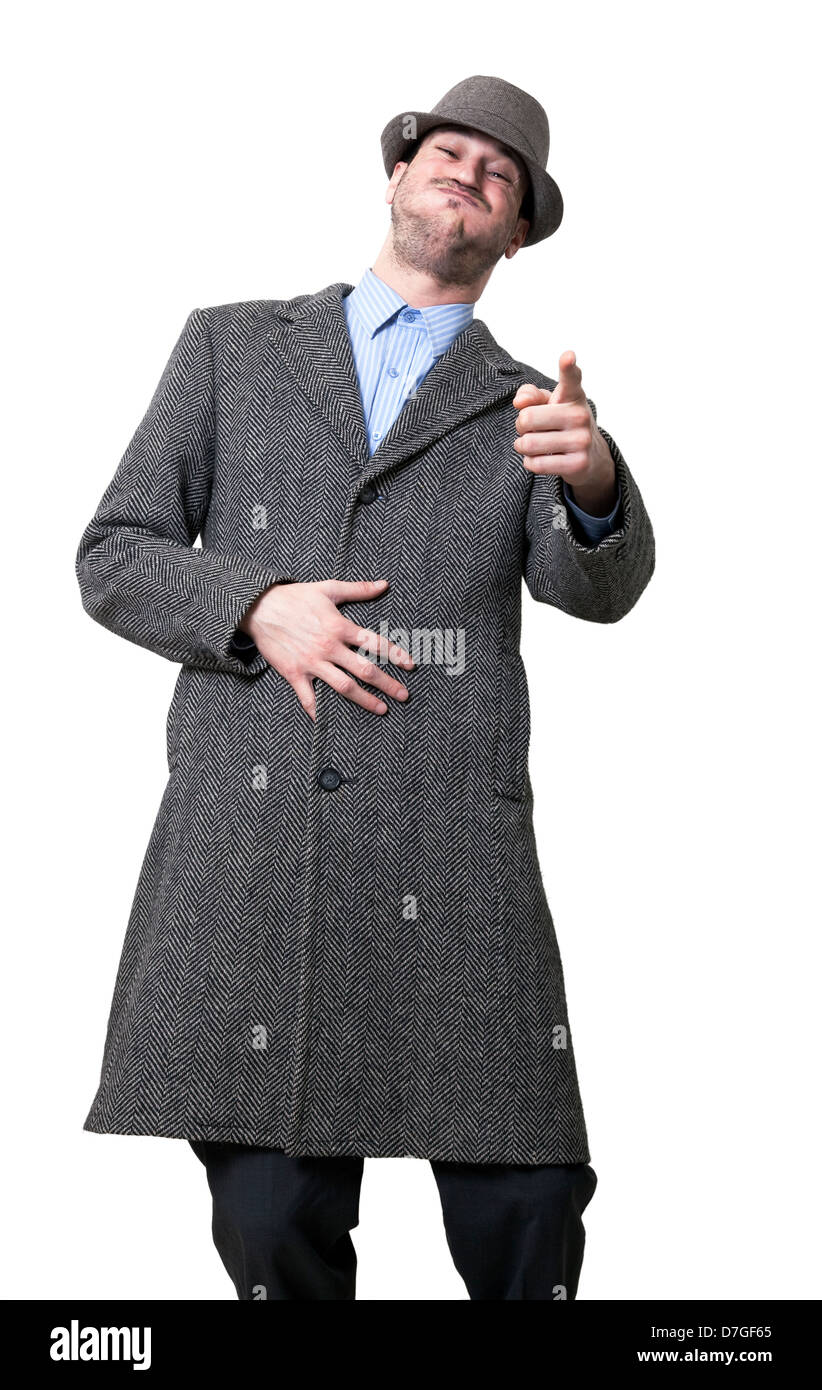 Un macho adulto joven vistiendo un abrigo maching hat busca apuntando a la cámara de la risa de ruptura. Aislado sobre fondo blanco. Foto de stock