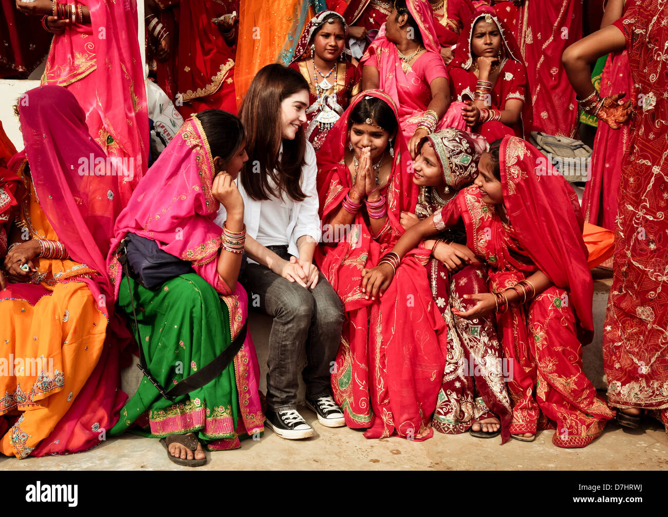 Extranjero chica es acogido por la India Rajasthani niñas en feria de Pushkar, Rajastán, India. Foto de stock