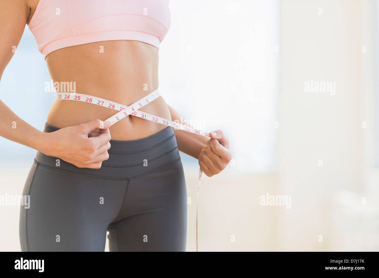 Cuerpo De La Mujer Con Una Cinta Métrica Medir Su Cintura Aislado En Un  Fondo Blanco Fotos, retratos, imágenes y fotografía de archivo libres de  derecho. Image 23123139