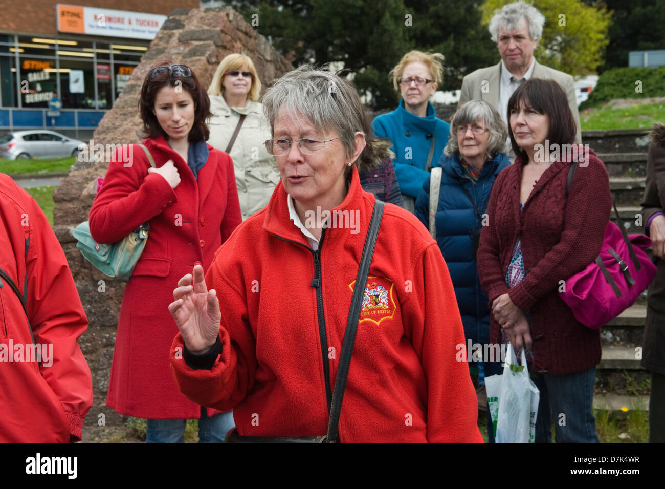 Chaqueta roja City Tour tour dando guía de sitios históricos en Exeter UK Foto de stock